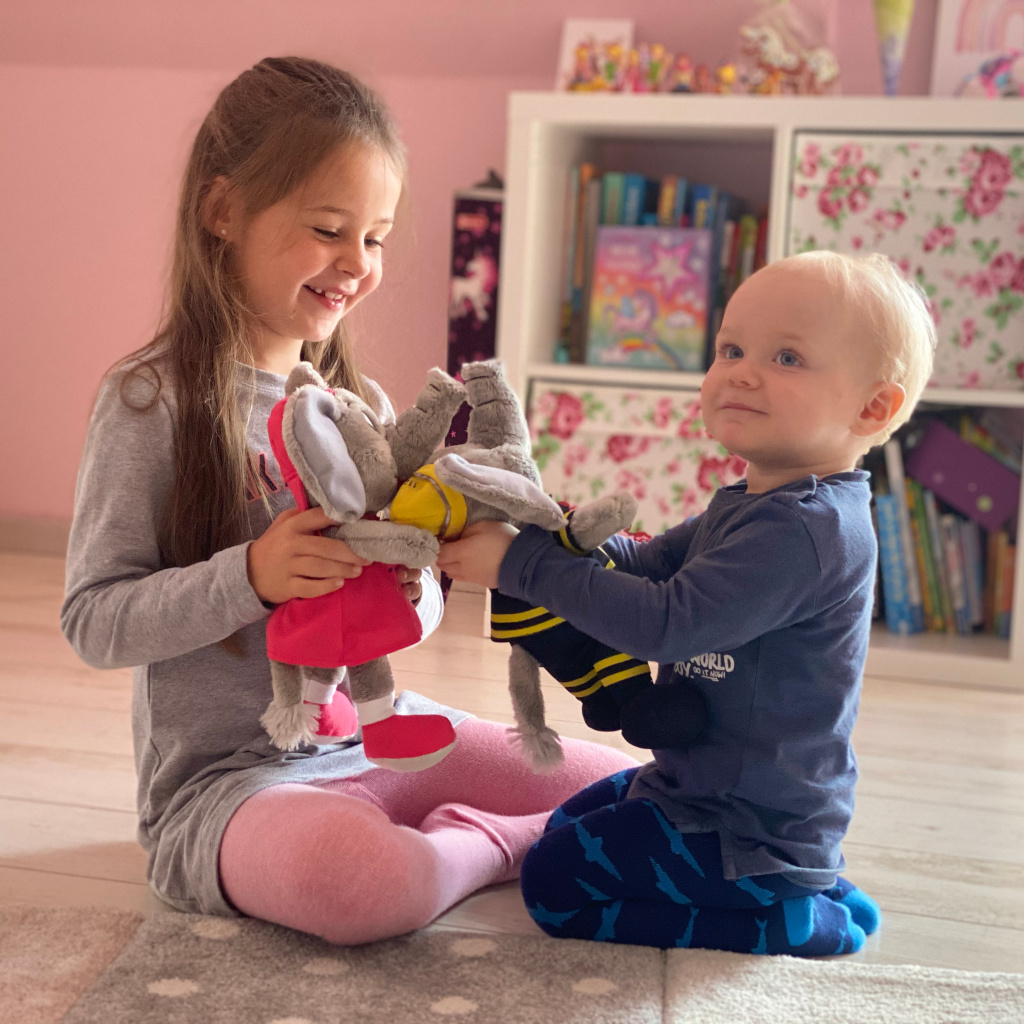 Kinder spielen mit Plüschtieren im Zimmer